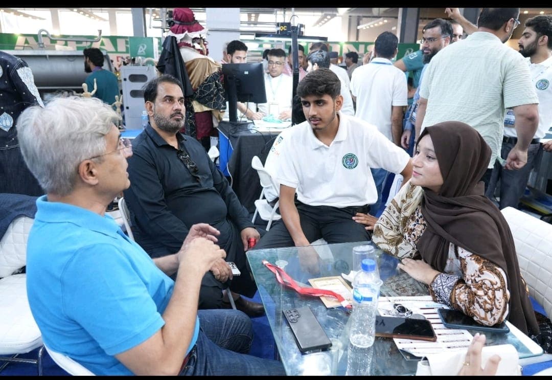 Hamza in a working discussion with a client at the exhibition table.